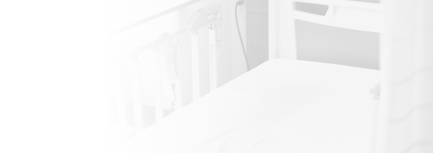 介護ベッドと安全柵が設置された居室。清潔で整理された空間。
